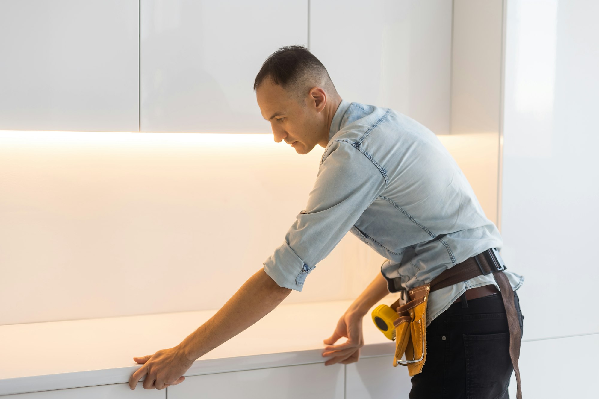 kitchen installation. Worker assembling furniture.